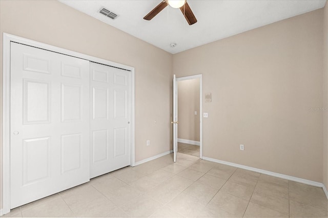 unfurnished bedroom featuring baseboards, light tile patterned floors, a closet, and ceiling fan