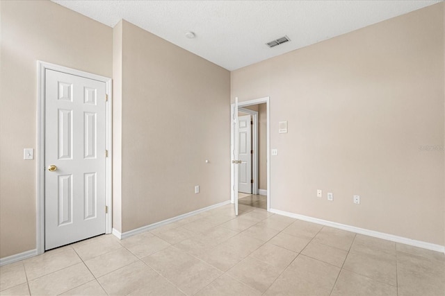 unfurnished room with light tile patterned floors and baseboards