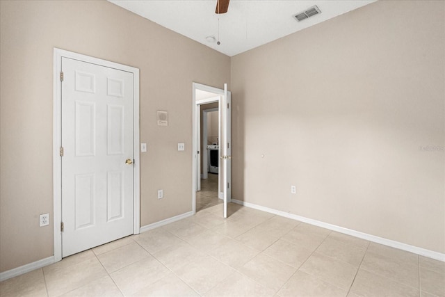 unfurnished bedroom with baseboards, light tile patterned flooring, and a ceiling fan
