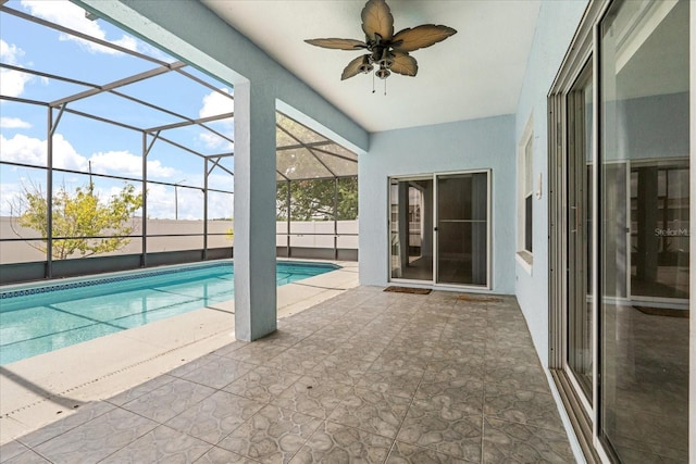 swimming pool with a patio area, a ceiling fan, and glass enclosure