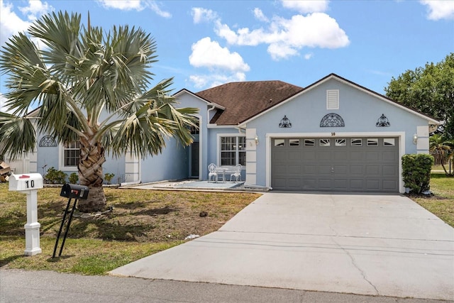 view of front facade with stucco siding, concrete driveway, and an attached garage