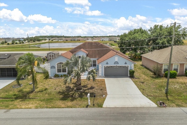 view of front of property featuring a garage, driveway, and a front lawn