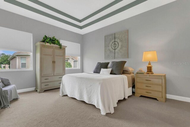 bedroom featuring light carpet and baseboards