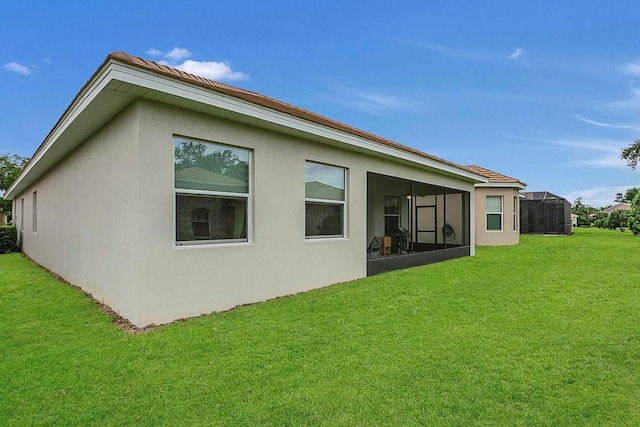 rear view of property with stucco siding and a yard