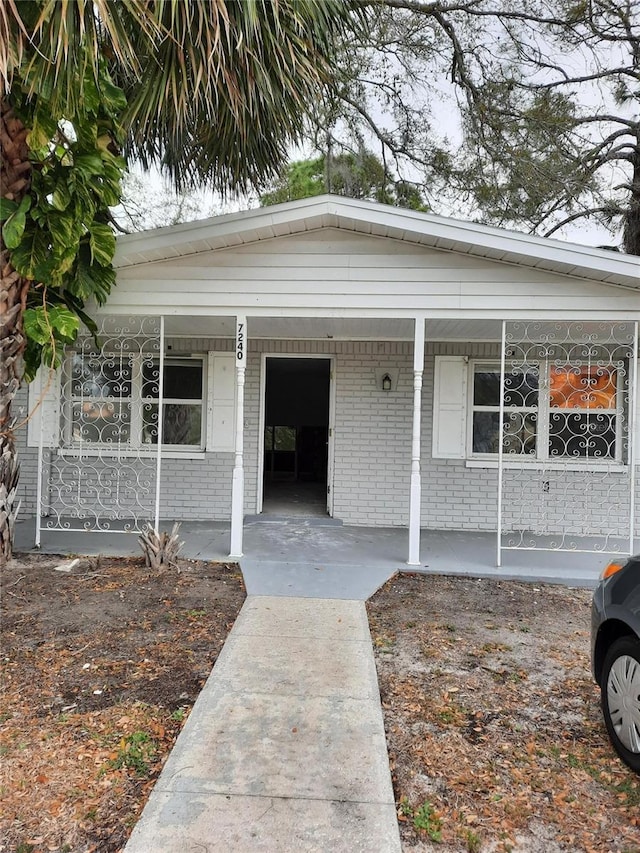 7240 Donna Dr, New Port Richey, FL 34652 - view of front of property featuring a porch and brick siding
