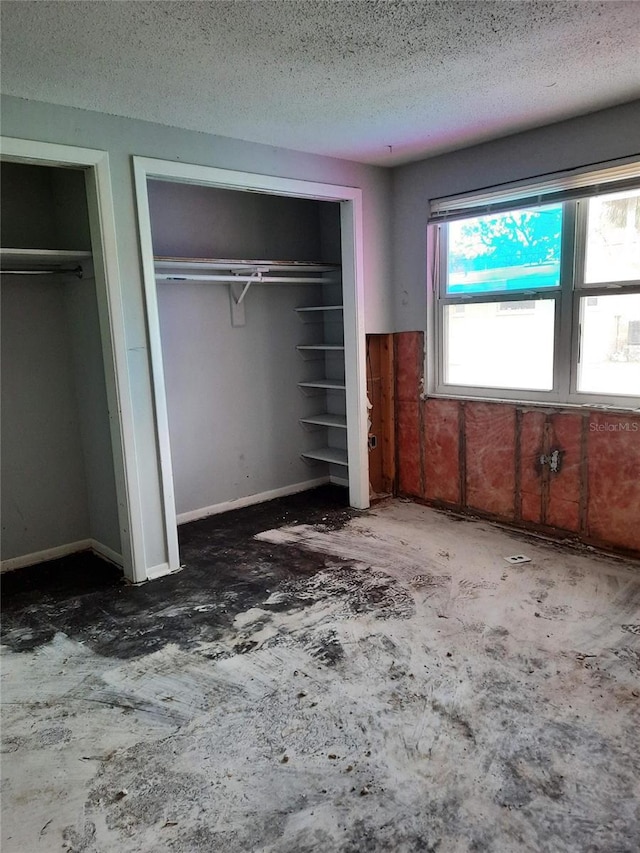 7240 Donna Dr, New Port Richey, FL 34652 - unfurnished bedroom with multiple closets and a textured ceiling