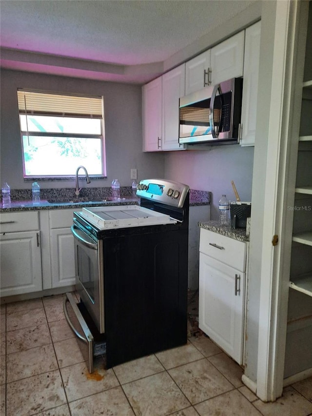 7240 Donna Dr, New Port Richey, FL 34652 - kitchen featuring appliances with stainless steel finishes, a sink, white cabinetry, stone countertops, and a textured ceiling