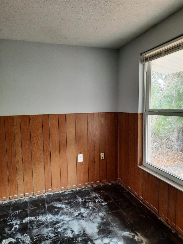 7240 Donna Dr, New Port Richey, FL 34652 - spare room with wooden walls, wainscoting, healthy amount of natural light, and a textured ceiling