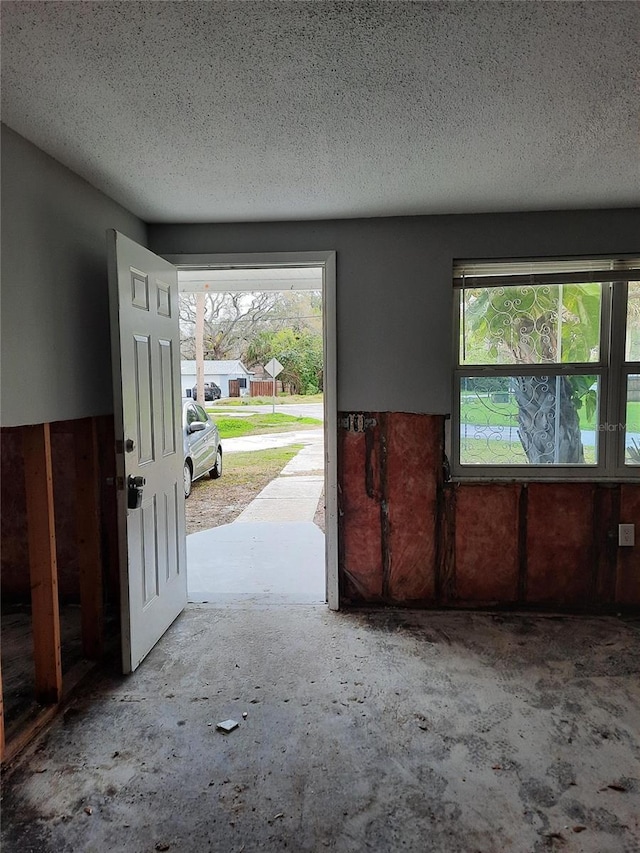 7240 Donna Dr, New Port Richey, FL 34652 - entryway with healthy amount of natural light, a textured ceiling, and unfinished concrete flooring