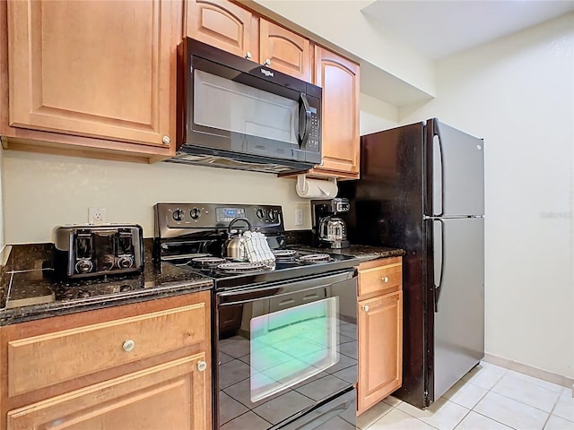 8101 Resort Village Dr, Orlando, FL 32821 - kitchen featuring black appliances, dark stone counters, light tile patterned floors, and baseboards
