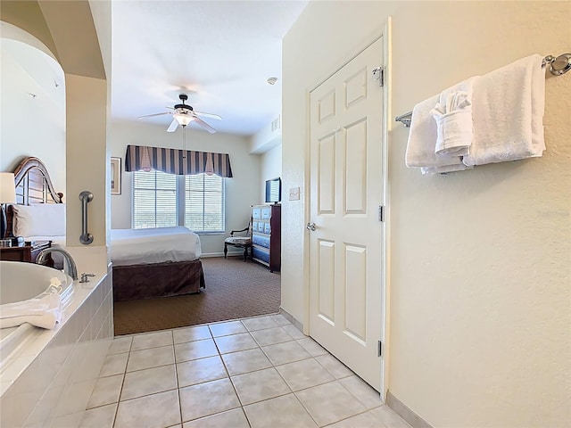 8101 Resort Village Dr, Orlando, FL 32821 - ensuite bathroom with tile patterned floors, a ceiling fan, a bath, and baseboards