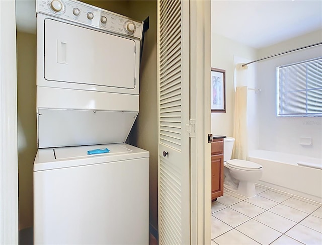 8101 Resort Village Dr, Orlando, FL 32821 - laundry area featuring stacked washer / dryer and light tile patterned flooring