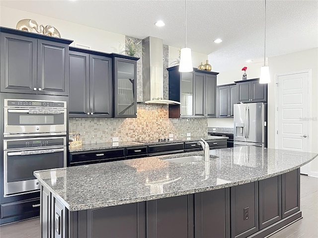 473 Oviedo Blvd, Oviedo, FL 32765 - kitchen with wall chimney range hood, stainless steel appliances, a sink, light stone countertops, and a large island