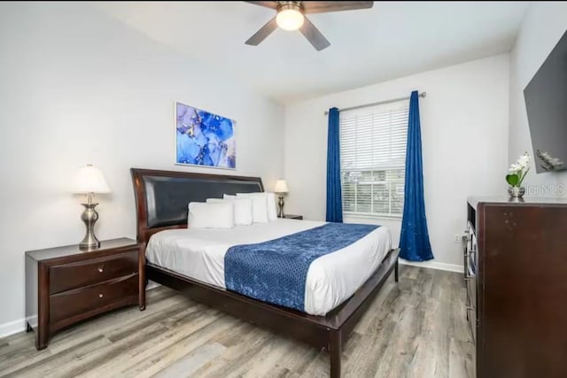 bedroom with wood finished floors, baseboards, and ceiling fan