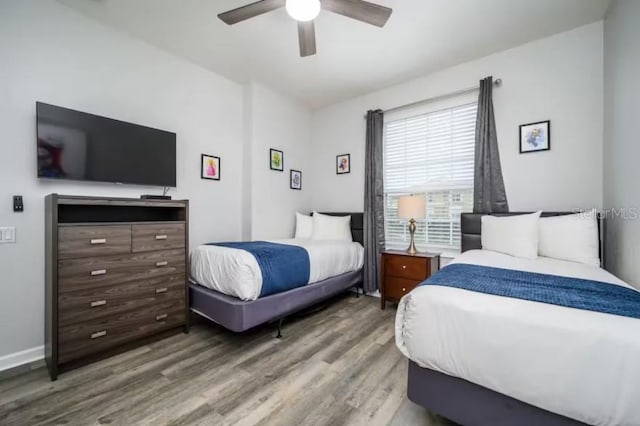 bedroom with wood finished floors, a ceiling fan, and baseboards
