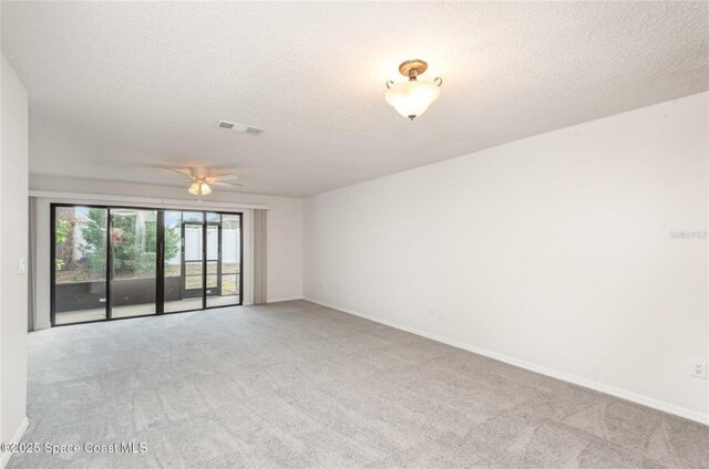 3164 Finsterwald Dr Unit 3164, Titusville, FL 32780 - spare room featuring light carpet, ceiling fan, baseboards, and a textured ceiling