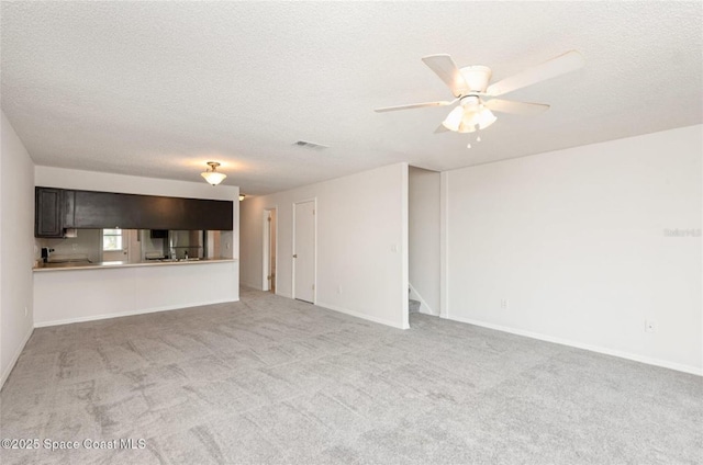 3164 Finsterwald Dr Unit 3164, Titusville, FL 32780 - unfurnished living room featuring light carpet, a ceiling fan, baseboards, a textured ceiling, and stairway