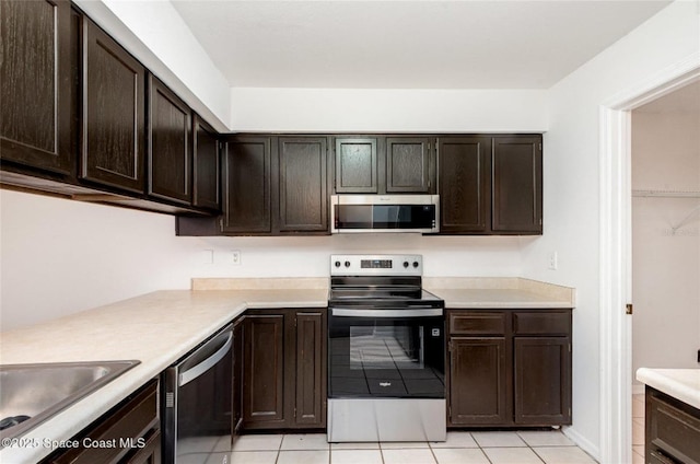 3164 Finsterwald Dr Unit 3164, Titusville, FL 32780 - kitchen with appliances with stainless steel finishes, light countertops, light tile patterned flooring, and dark brown cabinetry