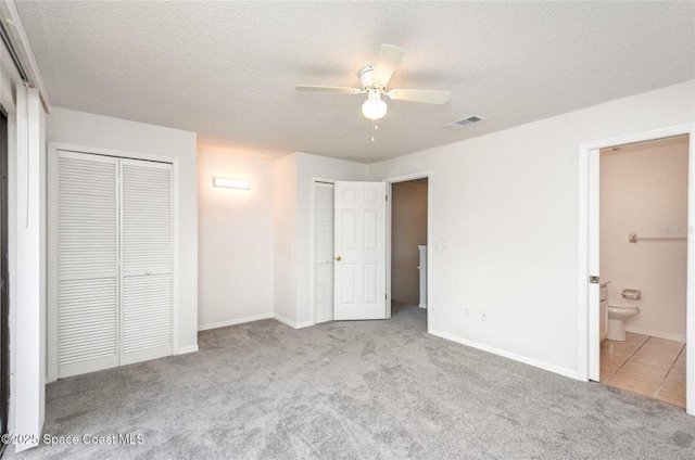 3164 Finsterwald Dr Unit 3164, Titusville, FL 32780 - unfurnished bedroom with two closets, carpet flooring, a textured ceiling, ensuite bathroom, and baseboards