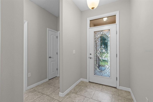 entryway featuring light tile patterned flooring and baseboards