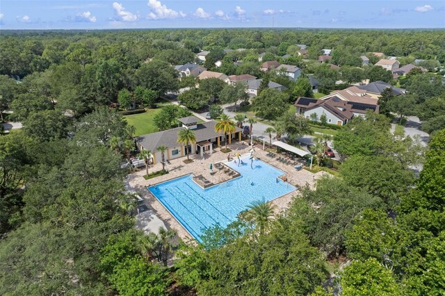 drone / aerial view of a pool area and a forest