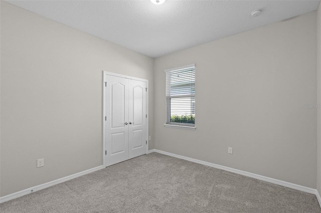 spare room featuring carpet, a smoke detector, and baseboards