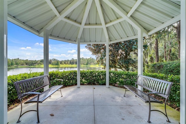 view of patio / terrace with a water view, view of scattered trees, and a gazebo
