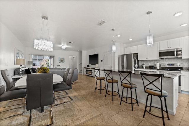 16162 Arbor Crest Aly, Winter Garden, FL 34787 - kitchen featuring appliances with stainless steel finishes, open floor plan, a chandelier, a breakfast bar area, and recessed lighting