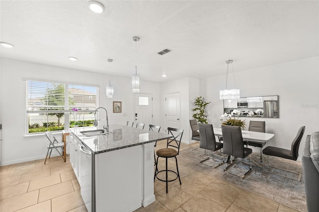 16162 Arbor Crest Aly, Winter Garden, FL 34787 - kitchen with a sink, stainless steel appliances, a breakfast bar, stone counters, and white cabinetry
