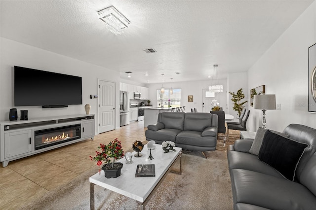 16162 Arbor Crest Aly, Winter Garden, FL 34787 - living room with light tile patterned flooring, a textured ceiling, and a glass covered fireplace