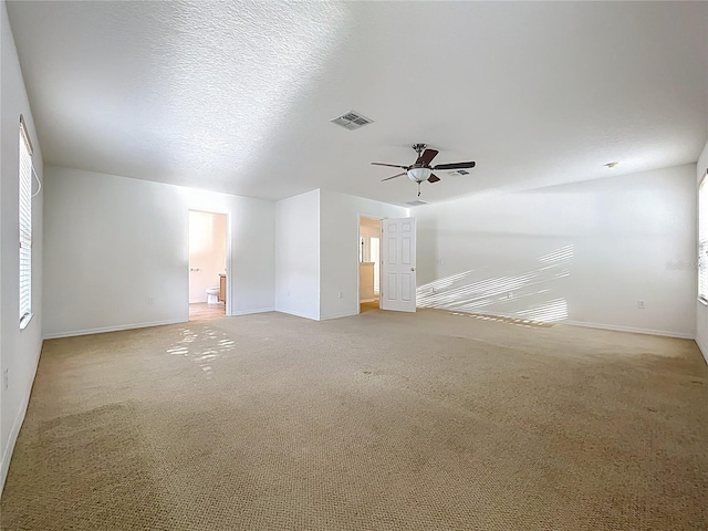 empty room with baseboards, a ceiling fan, and light colored carpet