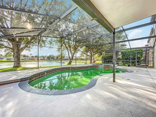 view of swimming pool featuring a patio, a pool with connected hot tub, a water view, and glass enclosure