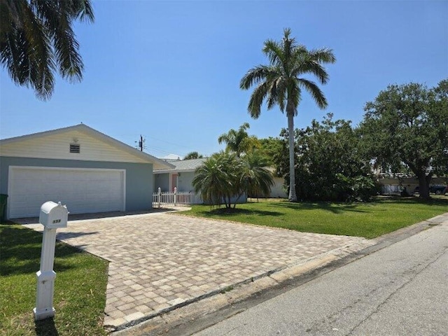 ranch-style house with a garage and decorative driveway