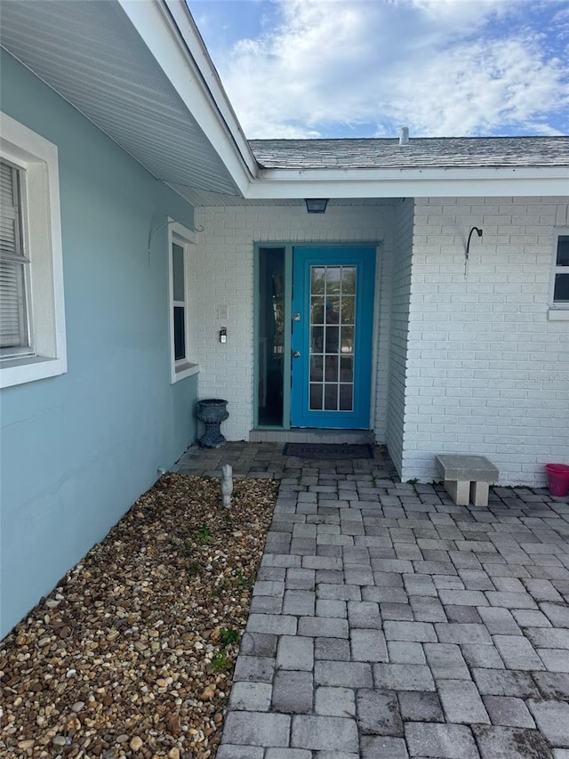 doorway to property featuring brick siding