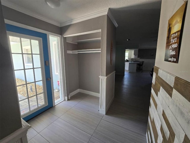 hallway with crown molding, tile patterned floors, and baseboards