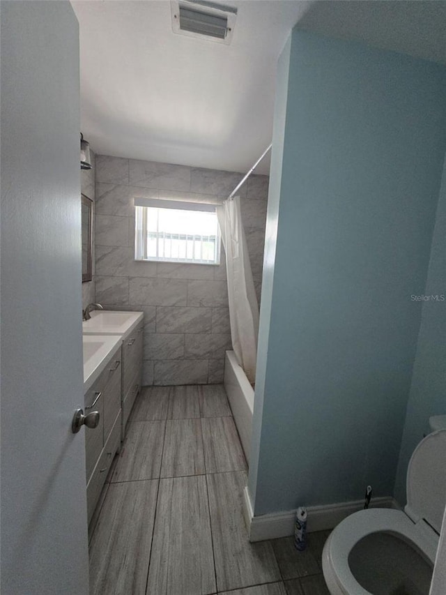 full bathroom with toilet, vanity, and shower / bath combo with shower curtain