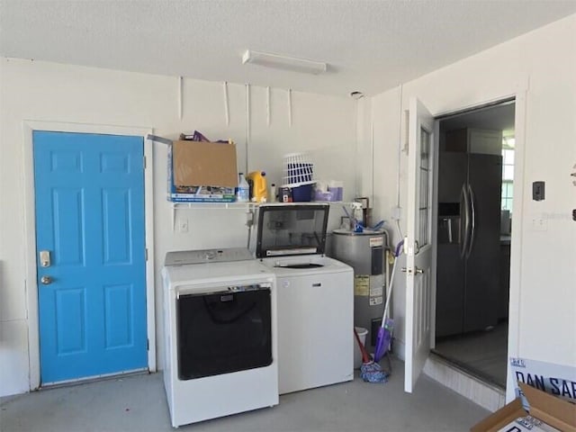laundry room featuring washing machine and dryer, water heater, and a textured ceiling