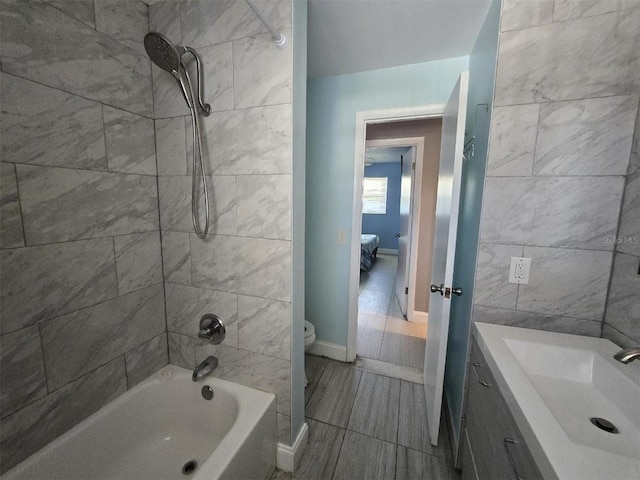 bathroom featuring shower / bathtub combination, toilet, ensuite bathroom, baseboards, and vanity