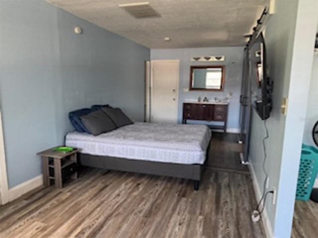 bedroom with wood finished floors and baseboards