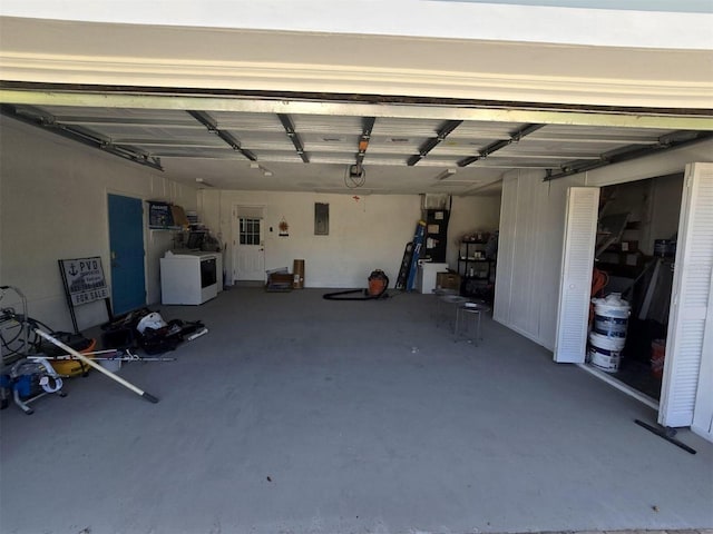 garage featuring washer and clothes dryer, electric panel, and heating unit