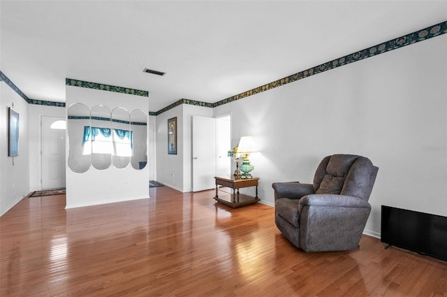 sitting room with wood finished floors and baseboards