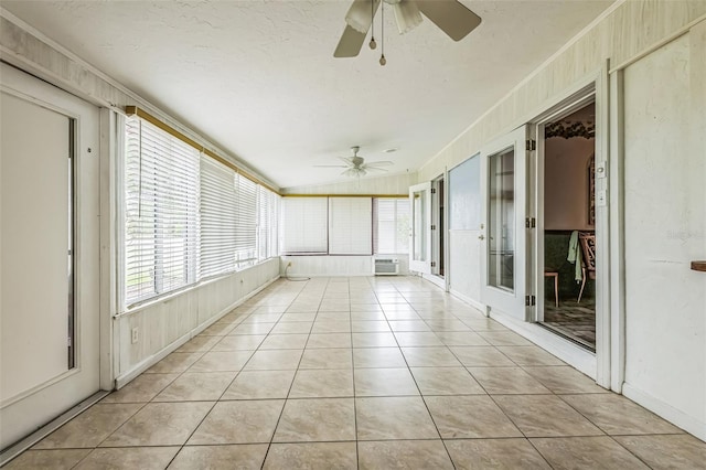 unfurnished sunroom featuring tile patterned floors, a wall mounted AC, ornamental molding, and a textured ceiling