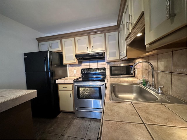 kitchen with stainless steel appliances, under cabinet range hood, a sink, tile countertops, and backsplash