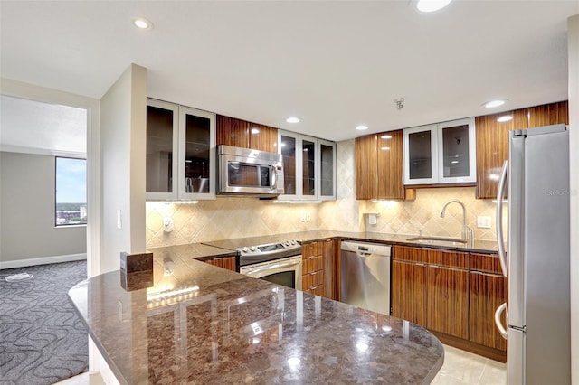 kitchen with appliances with stainless steel finishes, a sink, a peninsula, modern cabinets, and recessed lighting