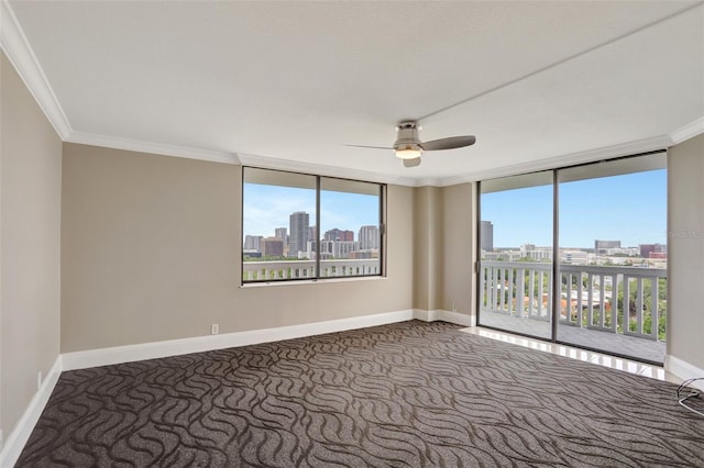 spare room with carpet, a ceiling fan, a skyline view, crown molding, and plenty of natural light