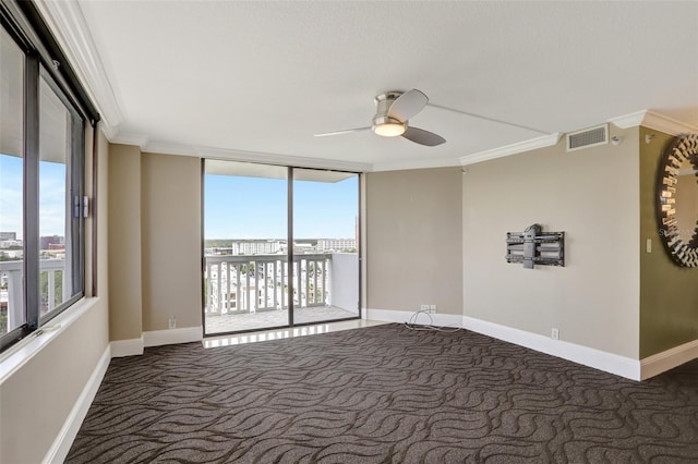 carpeted spare room with ceiling fan, ornamental molding, a wall of windows, and baseboards