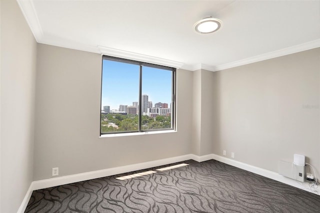empty room with carpet, baseboards, and ornamental molding