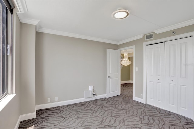 unfurnished bedroom with ornamental molding, carpet, baseboards, and a closet