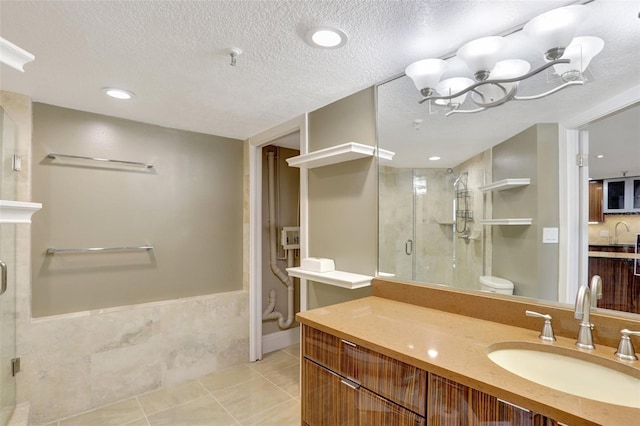 full bath featuring a shower stall, toilet, tile patterned flooring, vanity, and a textured ceiling