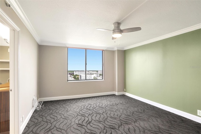 unfurnished room featuring dark colored carpet, ceiling fan, ornamental molding, and baseboards